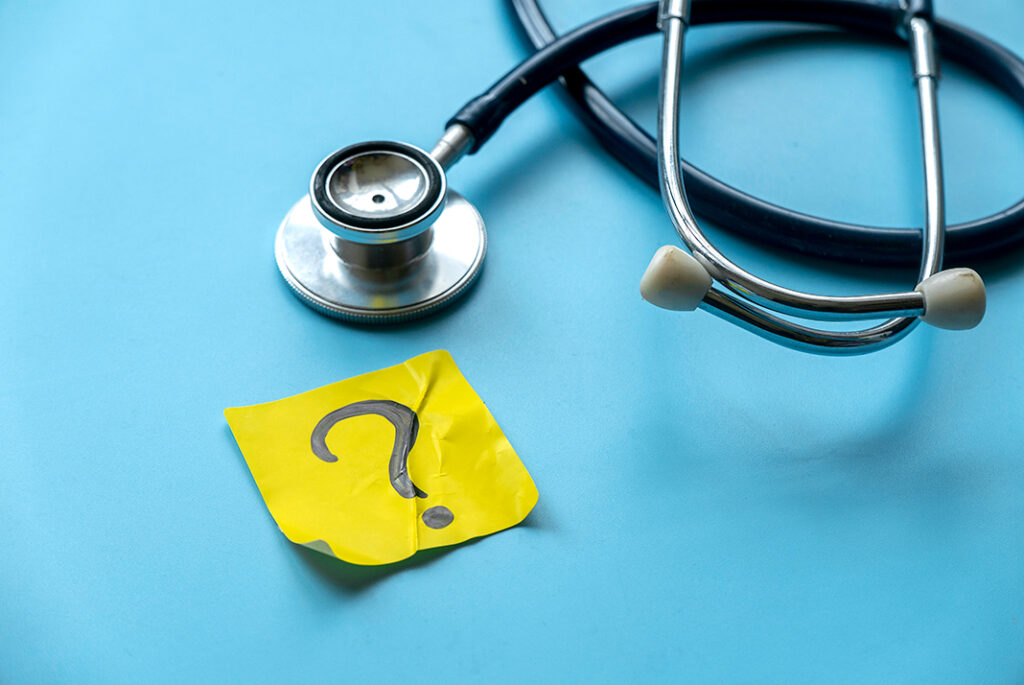 an image of a post it note with a question mark and a stethoscope. 